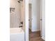 Tiled shower with mosaic accent, white tub, black fixtures, wood-look floor at 6709 Londonderry Dr, Morrow, GA 30260