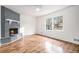 Bright living room with wood floors, a cozy fireplace, and large windows overlooking the front yard at 6709 Londonderry Dr, Morrow, GA 30260