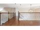 Upstairs hallway with hardwood floors, built-in shelving, and iron railings at 1472 Lachona Ct, Atlanta, GA 30329