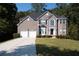 Brick home with a two-car garage and a well-manicured lawn at 3688 Eagles Beek Cir, Lithonia, GA 30038