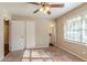 Bright bedroom with carpet, double doors, and a ceiling fan at 2126 River Rd, Ellenwood, GA 30294
