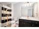 Modern bathroom with dark vanity, and a black and white shower curtain at 1142 Preserve Park Dr, Loganville, GA 30052
