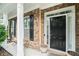 Front porch with rocking chairs and black front door at 1142 Preserve Park Dr, Loganville, GA 30052