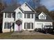 Two-story house with white siding, black shutters, and a pink door at 405 Baneberry Bnd, Peachtree City, GA 30269