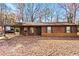 Brown siding ranch home with carport and leaf covered yard at 1762 Hunting Creek Se Ln, Conyers, GA 30013