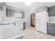 Galley kitchen with gray cabinets, white appliances, and marble countertops at 1762 Hunting Creek Se Ln, Conyers, GA 30013