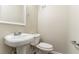 Half bathroom with a pedestal sink, toilet, and a neutral color palette at 1151 Martin Rd, Stone Mountain, GA 30088