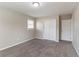 Empty bedroom with gray carpet, white closet doors, and a window at 1151 Martin Rd, Stone Mountain, GA 30088