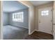 View of the entryway with a white door, wood-look flooring, and a glimpse into the carpeted living room at 1151 Martin Rd, Stone Mountain, GA 30088