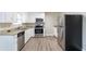 Modern kitchen featuring white cabinets, granite countertops, stainless steel appliances, and wood-look flooring at 1151 Martin Rd, Stone Mountain, GA 30088