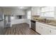 Kitchen with white cabinets, granite countertops, stainless steel appliances, and an open view to the living area at 1151 Martin Rd, Stone Mountain, GA 30088