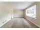 Spacious living room with plush gray carpeting, large windows, and neutral-colored walls at 1151 Martin Rd, Stone Mountain, GA 30088