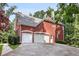 Three-car garage with white doors and a large driveway at 4390 River Rd, Ellenwood, GA 30294