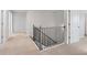 Upstairs hallway with carpet, neutral walls and black railing at 6949 Melody Dr, Buford, GA 30518