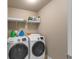 Laundry room with washer, dryer, and shelving at 1747 Castleberry Ln, Buford, GA 30518