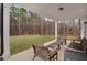 Covered back patio with outdoor furniture overlooking a grassy backyard and wooded area at 6101 Marigold Way, Atlanta, GA 30349