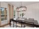Elegant dining room featuring a dark wood table, modern chandelier, and large windows at 6101 Marigold Way, Atlanta, GA 30349