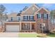 Inviting two-story home with brick and siding exterior, front porch, and attached garage at 6101 Marigold Way, Atlanta, GA 30349