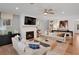 Living room with white brick fireplace, ceiling fan, hardwood floors, and ample seating at 6101 Marigold Way, Atlanta, GA 30349