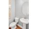Powder room with pedestal sink, oval mirror, and wood-like flooring at 6097 Marigold Way, Atlanta, GA 30349