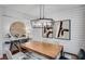 Dining area featuring a wood table, modern chandelier, and shiplap walls adorned with artwork at 6097 Marigold Way, Atlanta, GA 30349