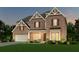 Inviting two-story brick home with a landscaped front yard and warm exterior lighting at 6097 Marigold Way, Atlanta, GA 30349