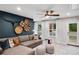 Cozy living room with plush sectional sofa, unique wall decor, and access to the outdoors at 6097 Marigold Way, Atlanta, GA 30349