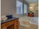 Spacious bathroom with large soaking tub, dark granite countertops, and wooden cabinetry at 1103 Etowah Valley Ln, Woodstock, GA 30189