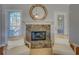 Cozy living room centered around a stone fireplace, framed by large windows at 1103 Etowah Valley Ln, Woodstock, GA 30189