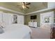 Main bedroom with king bed, access to bathroom, and TV at 9015 Niblick Dr, Alpharetta, GA 30022