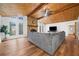 Living room with wood-beamed ceiling, stone fireplace, large windows, and wood floors at 2784 Sixes Rd, Canton, GA 30114