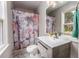 Bathroom with floral shower curtain, single sink vanity, and window at 3090 Karen Ne Ln, Marietta, GA 30062