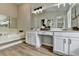 Double vanity bathroom with white cabinets and wood-look flooring at 1461 Howard Way, Lawrenceville, GA 30043