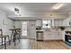 Eat-in kitchen with white cabinets, stainless steel appliances, and wood-look floors at 1461 Howard Way, Lawrenceville, GA 30043