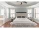 Light blue bedroom with tray ceiling, wood floors, and a white bed at 4835 Abberley Ln, Alpharetta, GA 30022