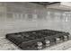 Close-up of kitchen gas stovetop and vent hood with a gray tiled backsplash at 1961 Enchanted Woods Trl, Marietta, GA 30066