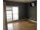 Empty bedroom featuring hardwood floors, large window, and gray walls at 209 Cobblestone Cv, Sharpsburg, GA 30277