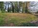 Sloped backyard featuring a storage shed, mature trees, and a mix of grass and groundcover at 2649 Toni Sw Pl, Marietta, GA 30060