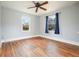 Empty bedroom with light blue walls, hardwood floors, ceiling fan, and two windows with blue curtains at 2649 Toni Sw Pl, Marietta, GA 30060