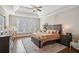 Main bedroom with hardwood floors, tray ceiling and large window at 5705 Windjammer Pt, Cumming, GA 30041