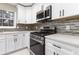 White kitchen cabinets, stainless steel appliances, and sleek black hardware at 934 Bay Ridge Dr, Lawrenceville, GA 30045