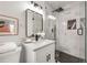 Modern bathroom with white vanity, marble tile shower, and black hexagonal floor tiles at 1951 Cummings Sw Dr, Atlanta, GA 30311