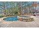 In-ground pool with a stone hot tub and surrounding trees at 219 Regency Ct, Acworth, GA 30102