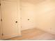 Empty bedroom with white walls, light wood-look floors, and white doors at 4001 Red Oak Dr, Atlanta, GA 30340