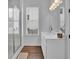 Modern bathroom with white vanity, marble shower, and wood-look tile at 812 Levi Farms Ln, Canton, GA 30115