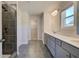 Modern main bathroom with dual vanity, tiled shower, and gray cabinets at 224 Chiswick Loop, Stockbridge, GA 30281