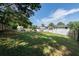 Large, grassy backyard with a white house, trees, and a patio area at 5573 Prince Phillip Way, Stone Mountain, GA 30087