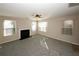 Living room with a fireplace, ceiling fan, and large windows providing natural light at 6135 Smoke Ridge Ln, Cumming, GA 30041