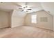 Secondary bedroom with sloped ceiling, neutral carpet, and a bright window at 2340 Arnold Palmer Way, Duluth, GA 30096