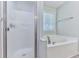 Modern bathroom featuring a soaking tub, separate shower, and frosted glass door at 5229 Boone Ct, Villa Rica, GA 30180